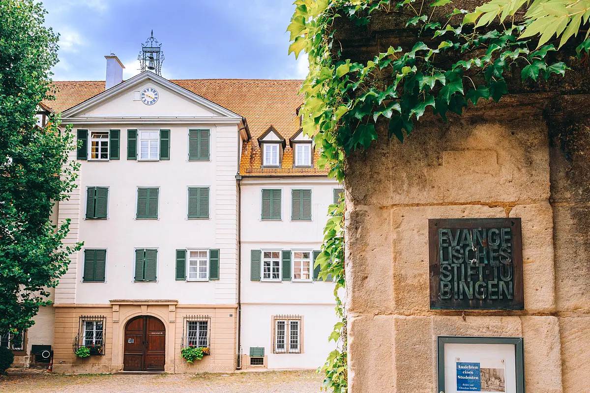 Frontaufnahme des Stifts mit Schild "Evangelisches Stift" an der Mauer