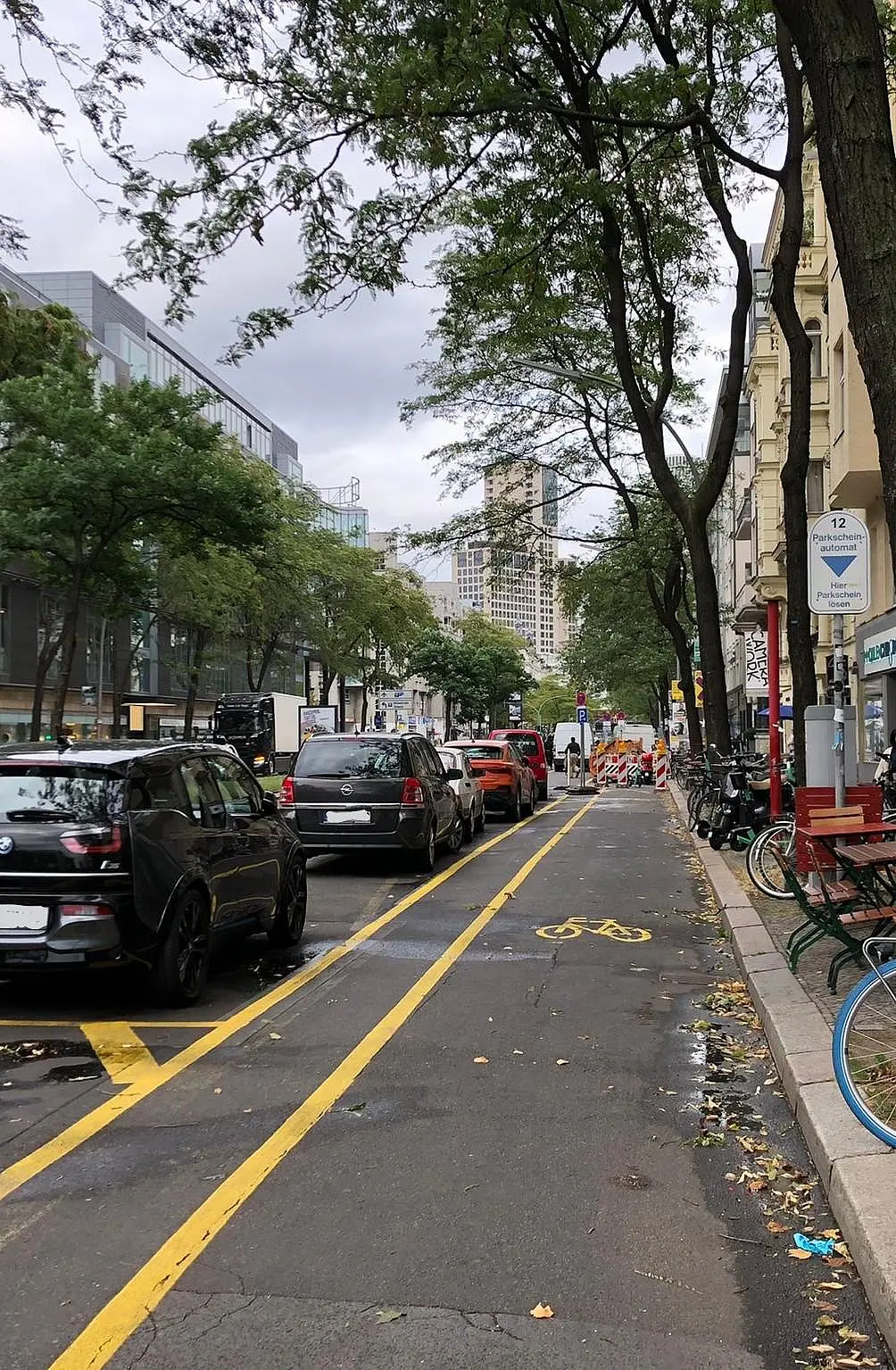 Ein Fahrradweg neben parkenden Autos im Zentrum einer Großstadt