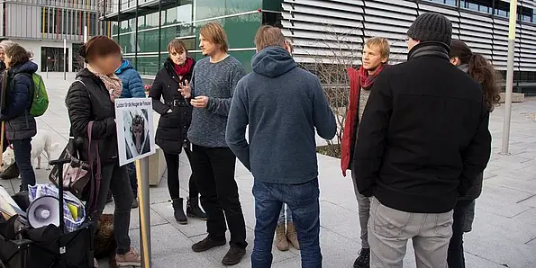 Protesters are standing in front of the HIH/CIN building