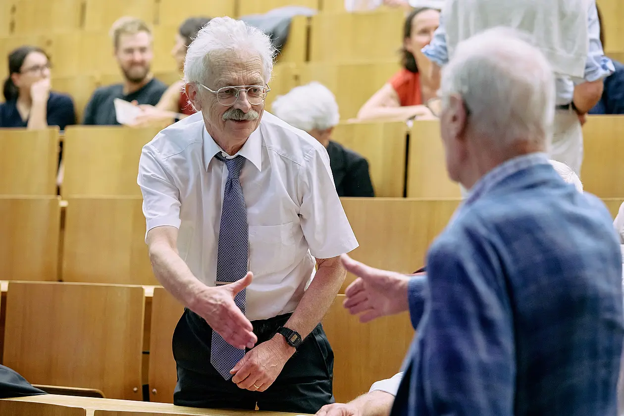 Prof. Dr. Rammensee gibt im Hörsaal zur Verabschiedung einer Person die Hand.
