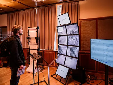 Besucher bei der Science Fair vor Bildschirmen