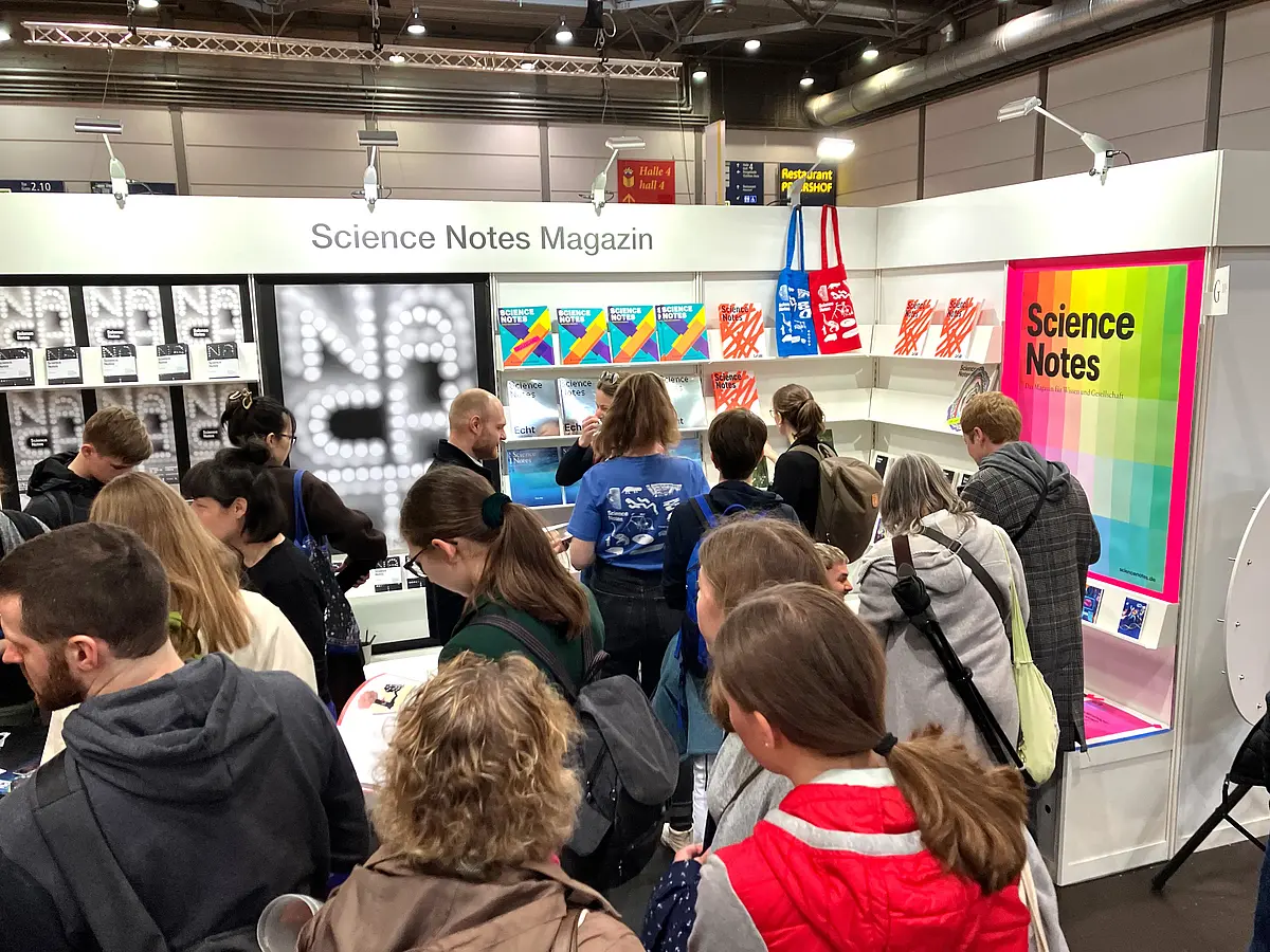 Menschen stehen an einem Stand auf einer Messe
