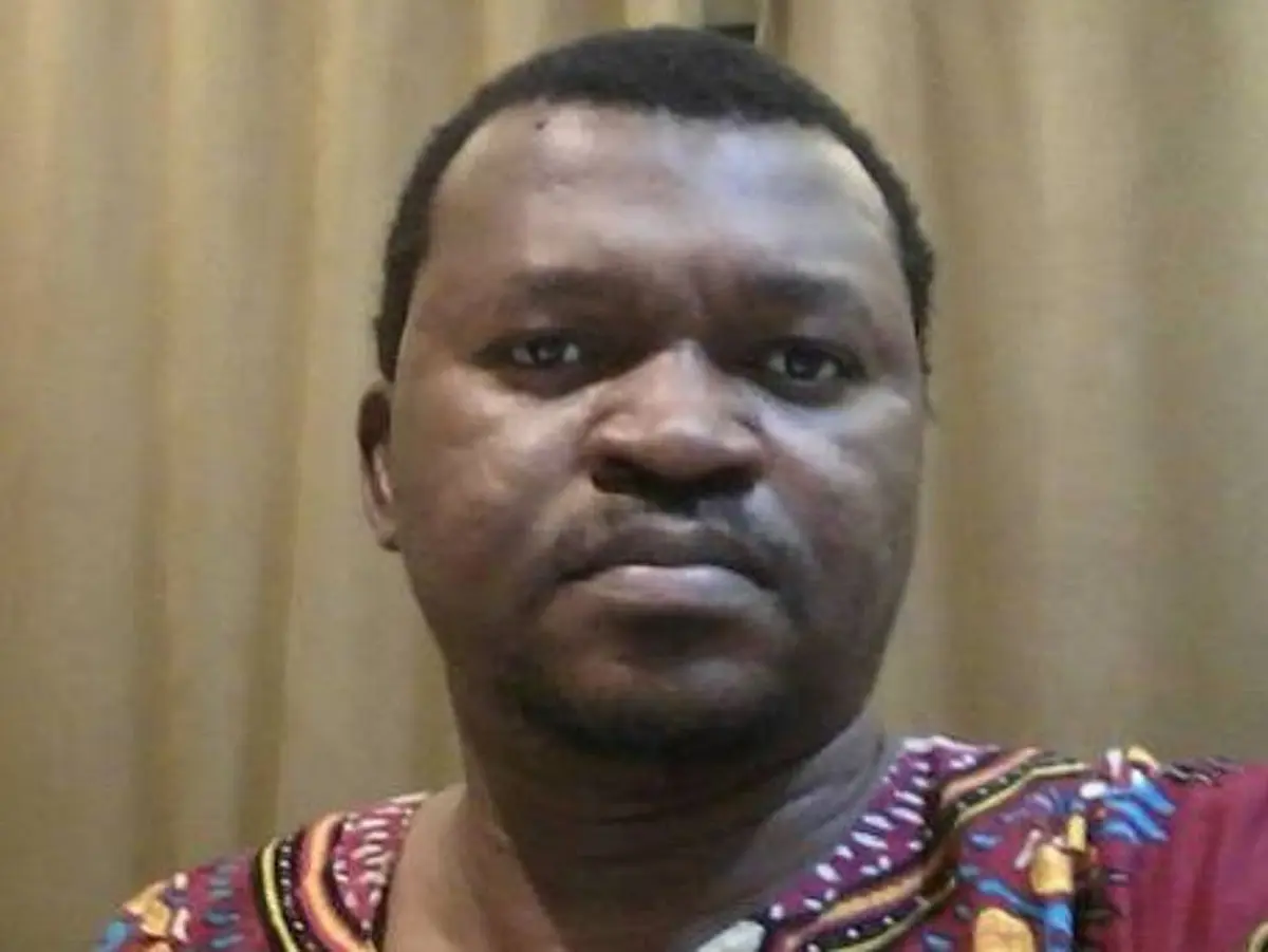 A man in his early 40s with dark short hair