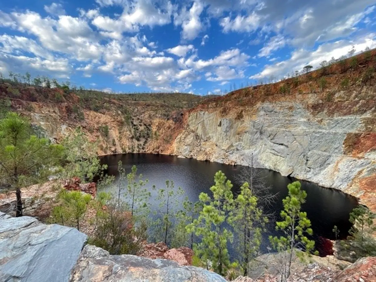 View of Rio Tintos with its dark red water surrounded by dry vegetation