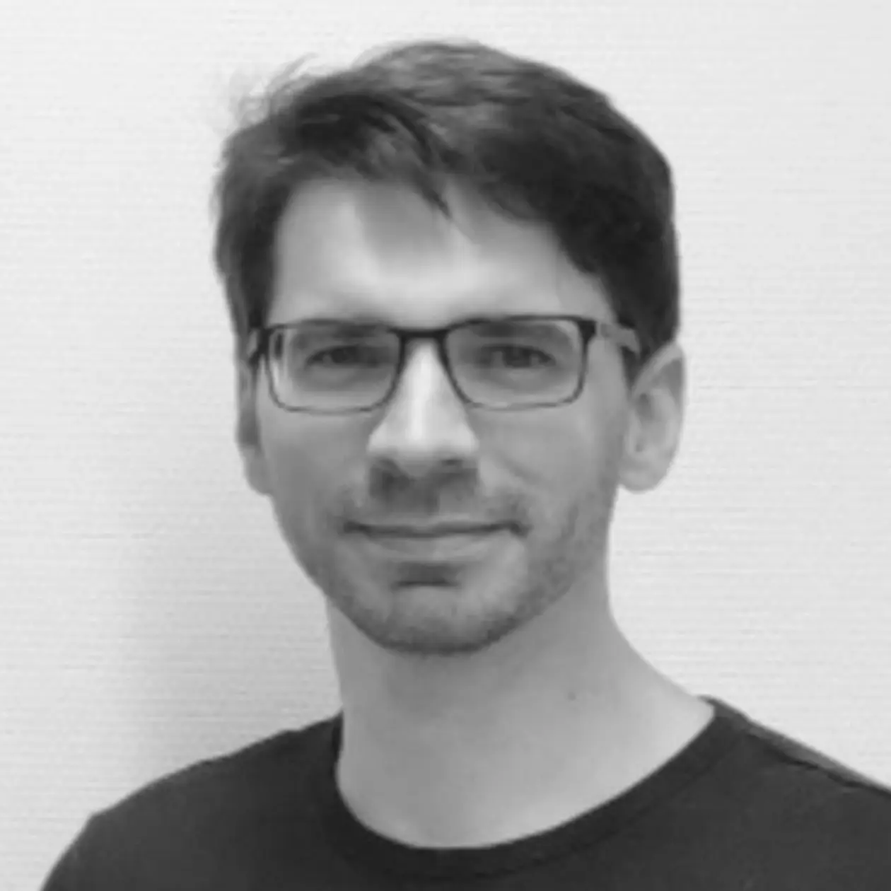 A black and white photo of Severin Opel, a white man wearing rectangular glasses and with short dark hair. 