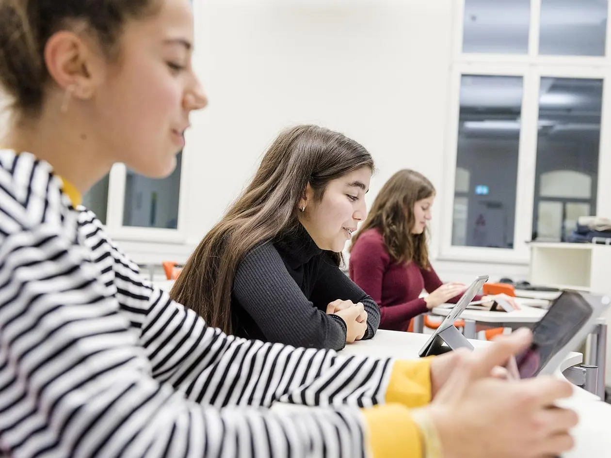 Schülerinnen arbeiten im Unterricht mit Tablets