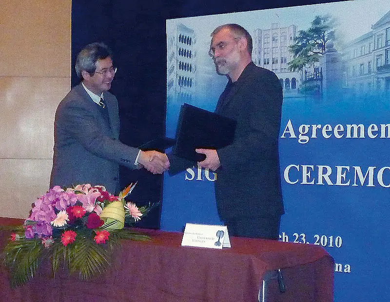 Prof. Dr. Zhang Xu, Vizepräsident des Shanghai Institutes of Biological Sciences, überreicht den Kooperationsvertrag an Prof. Dr. Hermann Schlüsener (rechts) vom Institut für Hirnforschung der Universität Tübingen.