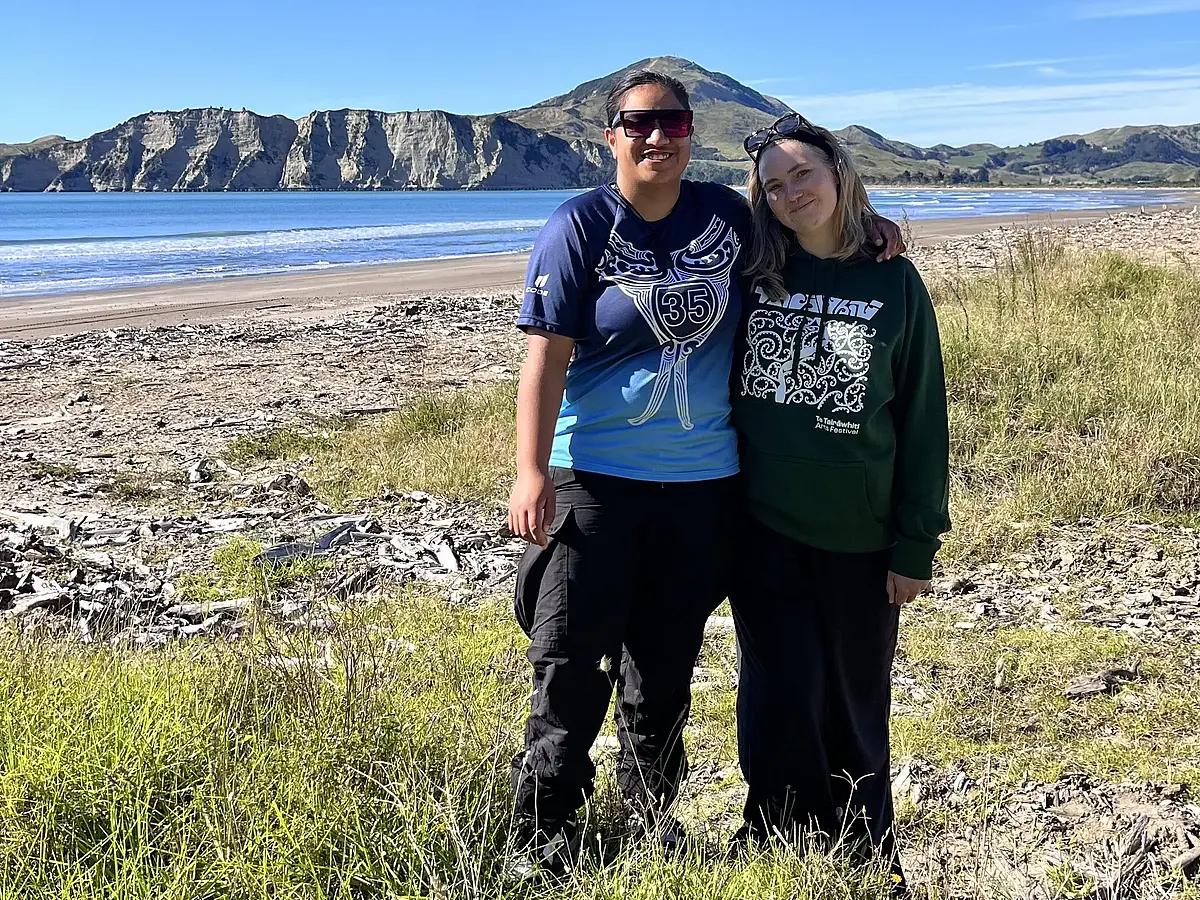 Naomi Lüderitz und Maori-Frau  Tapuhi Tautau Broughton Tuapawa vor Meeresbucht mit Bergen im Hintergrund