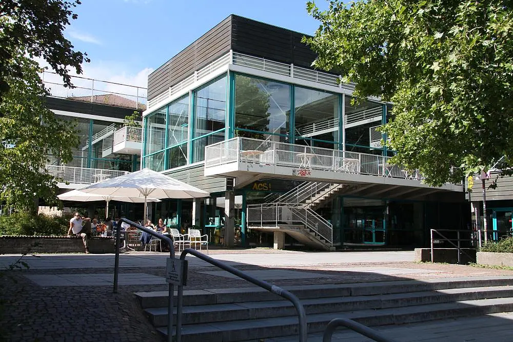 Außenansicht der Mensa Wilhelmstraße von der Wilhelmstraße aus mit Treppenaufgang und Außenbereich der Cafeteria..