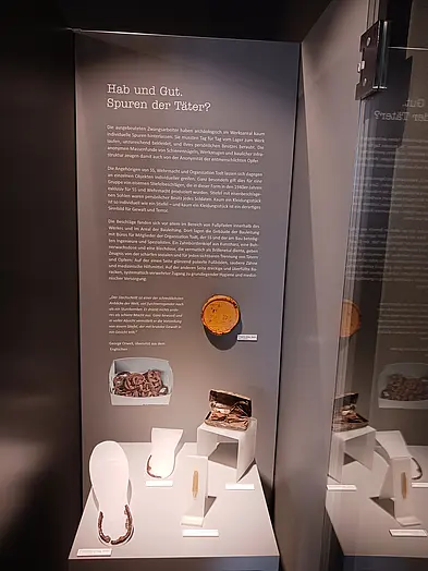 Spuren der Täter? Vitrine mit archäologischen Funden, die Hinweise auf die Gruppe der Täter geben, darunter beispielsweise eiserne Fersenbeschläge von Militärstiefeln.