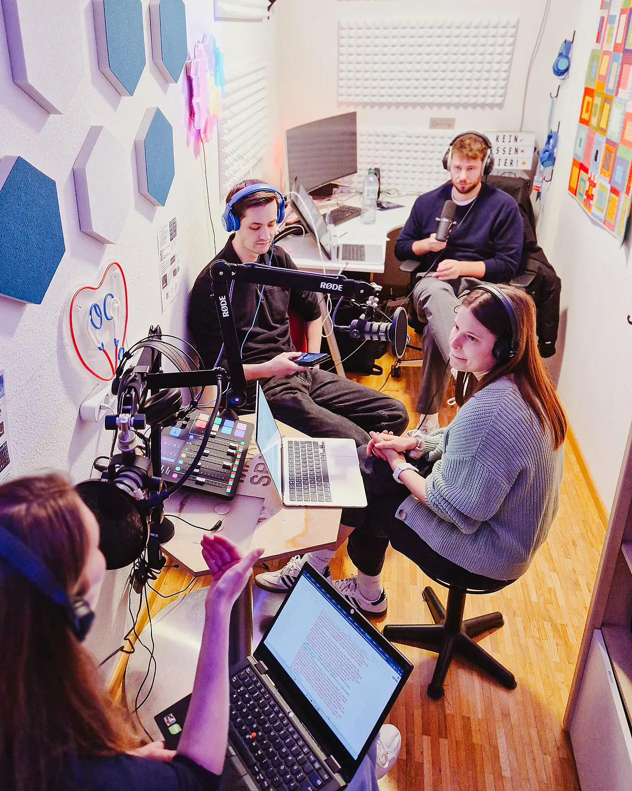 Vier Personen in einem Podcast-Aufnahmestudio