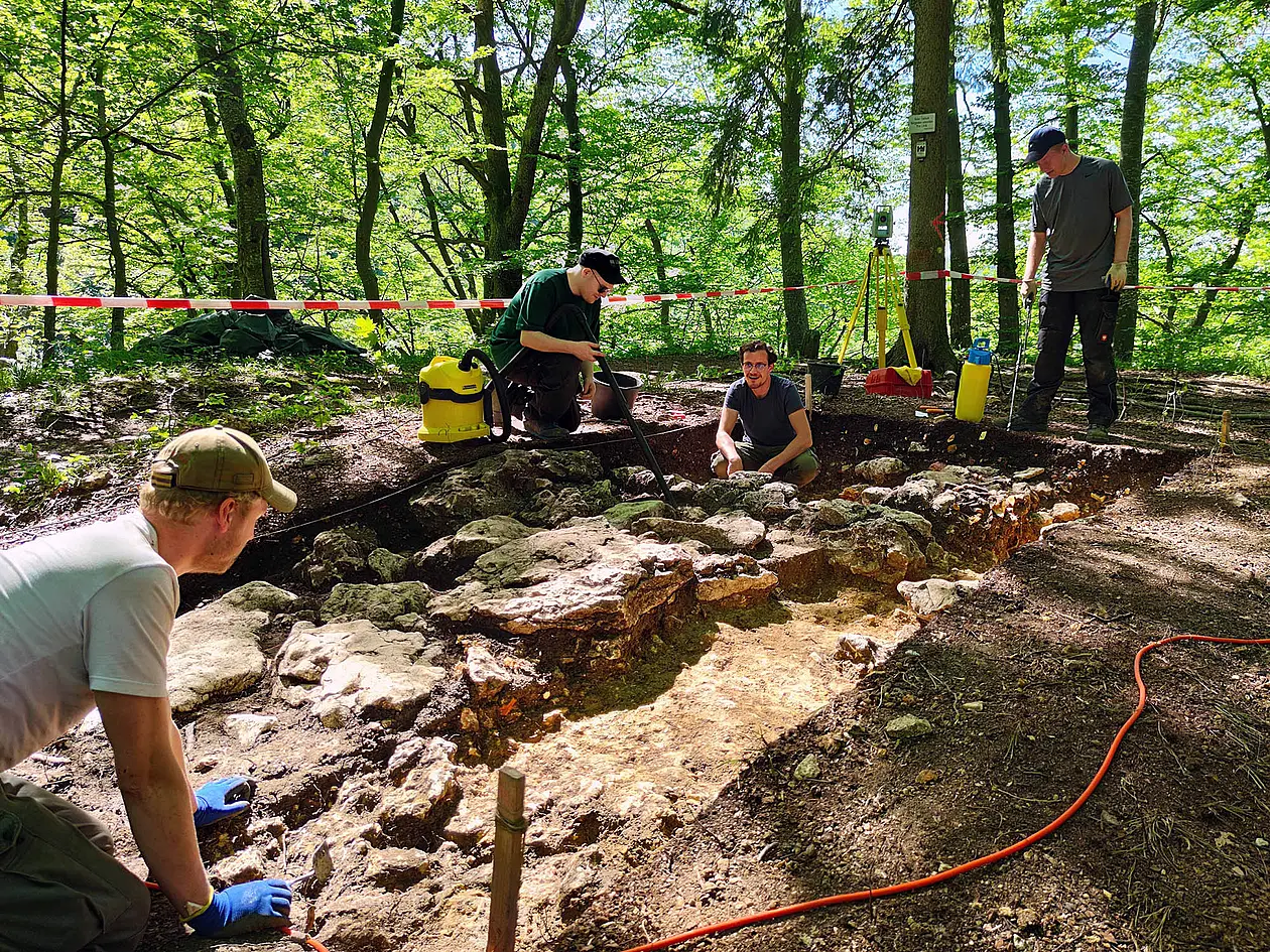  Personen arbeiten an der Freilegung der Mauerreste an Burg Stahleck in der Nähe von Reutlingen, 2021.