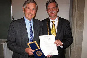 Rektor Professor Dr. Bernd Engler überreicht die Universitätsmedaille in Silber an Hans Günther Jansen (links im Bild). Foto: Gebhard Bieg