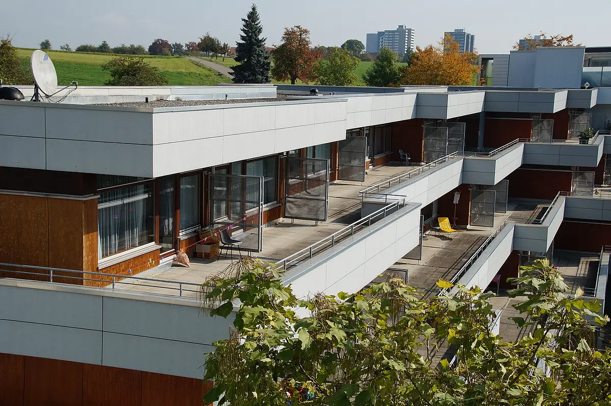Bild: Dreistöckiges Wohnhaus mit Terrassen im Vordergrund