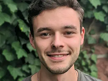 Die Fotographie zeigt Herrn Moritz Adam. Er lächelt in die Kamera.