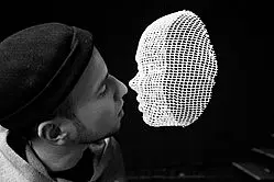 Male person approaches a computer-generated female face for a kiss