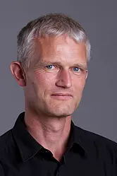 A male person in his late 40s with blond-white hair