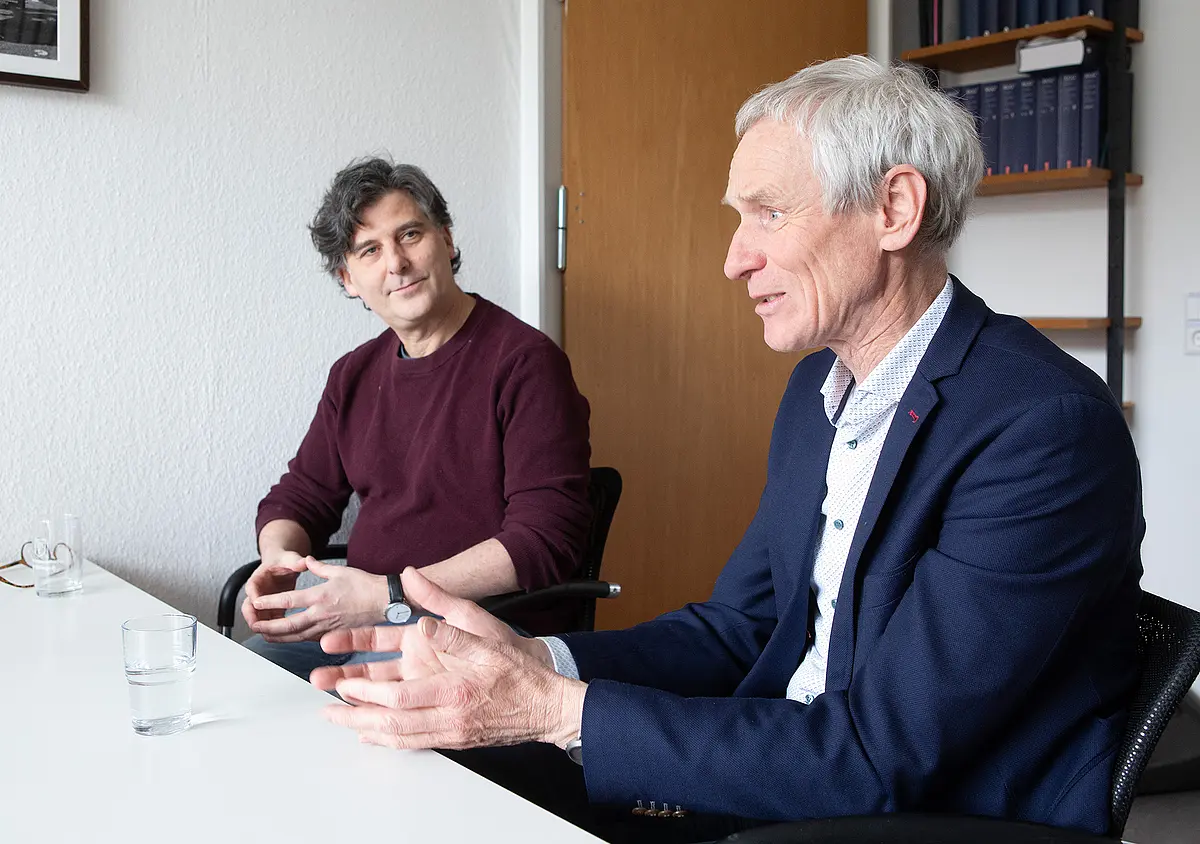 Der Historiker Ewald Frie und der Soziologe Boris Nieswand sietzen an einem Tisch und sind im Gespräch.