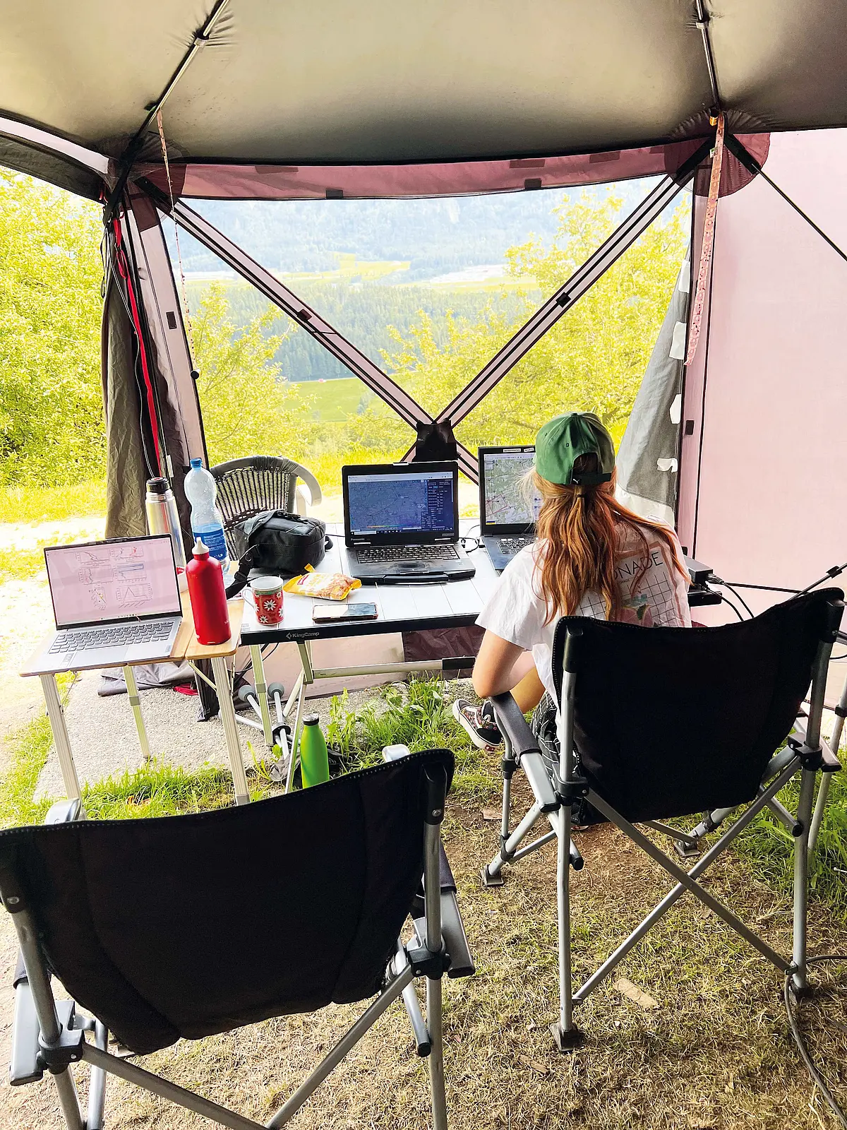 An den Laptops der Bodenstation kontrollierte das Team Wetterdaten. Eine Frau sitzt auf einem Campingstuhl, auf dem Tisch vor ihr ein Laptop.