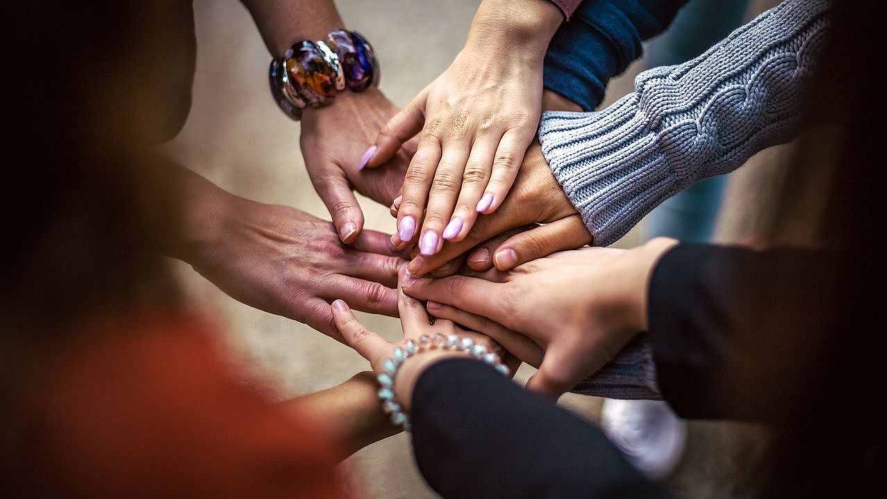 A decorative picture showing people of different ethnicities putting their hands over each other (link to the page Certificate of Education against Anti-Semitism and Anti-Muslim Racism) 