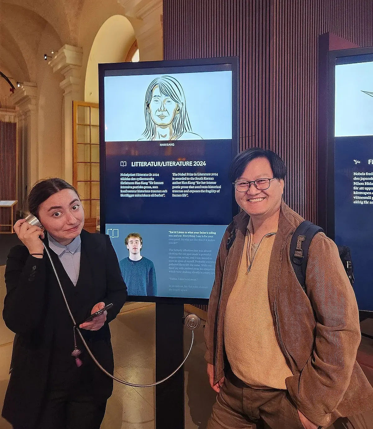 Professor You Jae Lee mit Studentin Paraschiva Ioana Balea im Nobelpreis-Museum in Stockholm, sie stehen vor einem Screen.