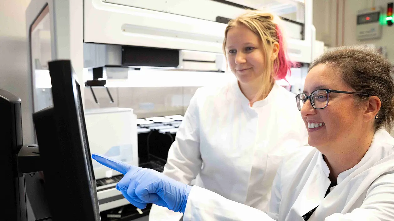 Die Wissenschaftlerin Ana Rita Brochado (rechts) und ihre Labormitarbeiterin Laura Sniegula blicken auf die Daten des Pipettierroboters.