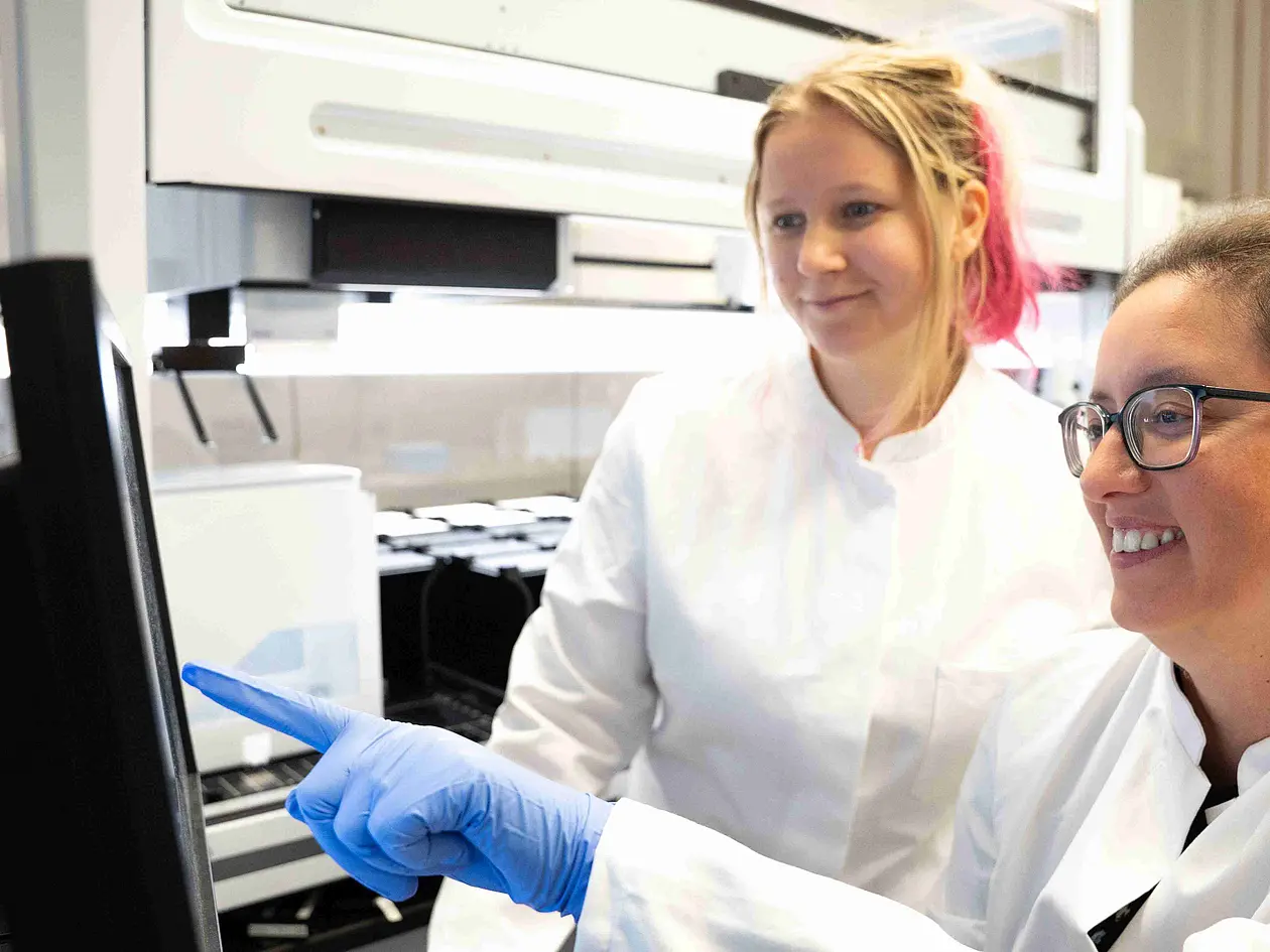 Die Wissenschaftlerin Ana Rita Brochado (rechts) und ihre Labormitarbeiterin Laura Sniegula blicken auf die Daten des Pipettierroboters.
