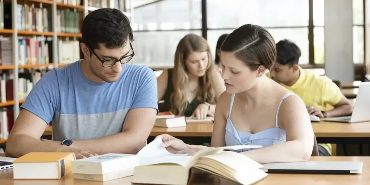 Studierende, die gemeinsam in der Bibliothek lernen.