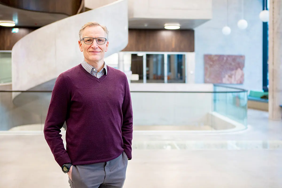 [Translate to Englisch:] Lars Angenent steht im Foyer des Geo- und Umweltforschungszentrums