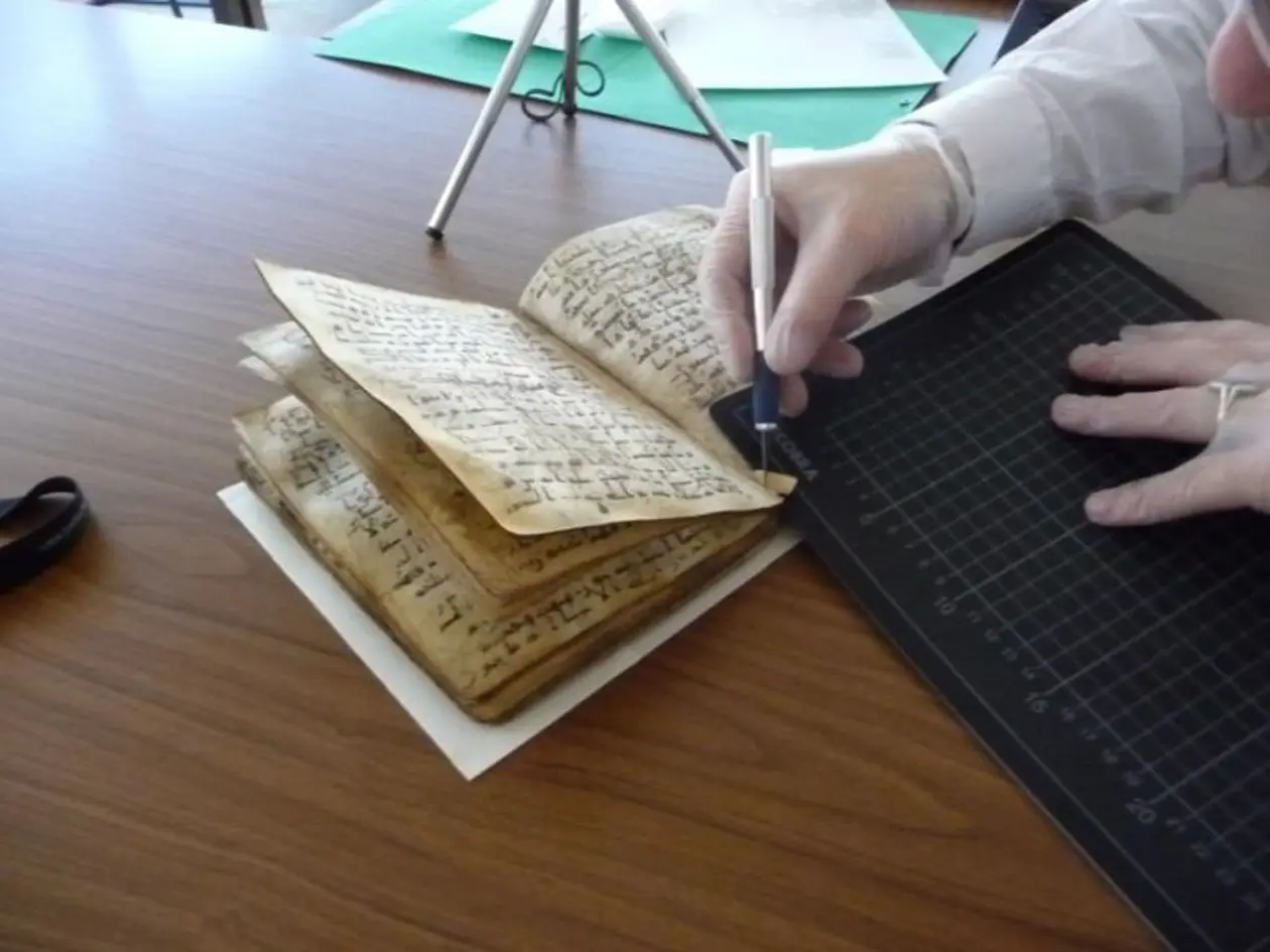 Ein Experte entnimmt der Koranhandschrift eine Probe für die Datierung. Foto: Dr. Wilfried Lagler/Universitätsbibliothek Tübingen