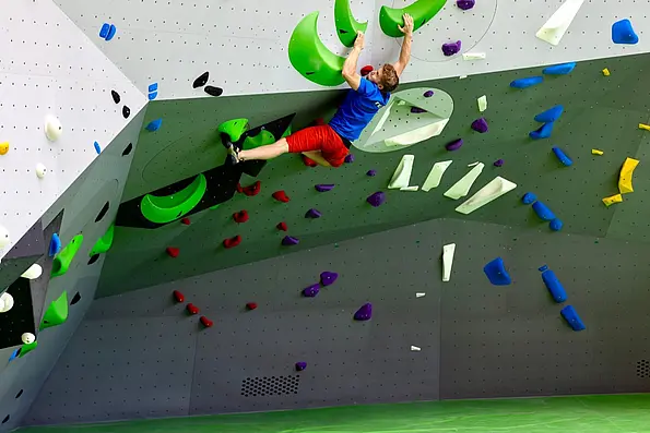 A man is bouldering inside the boulder hall B12