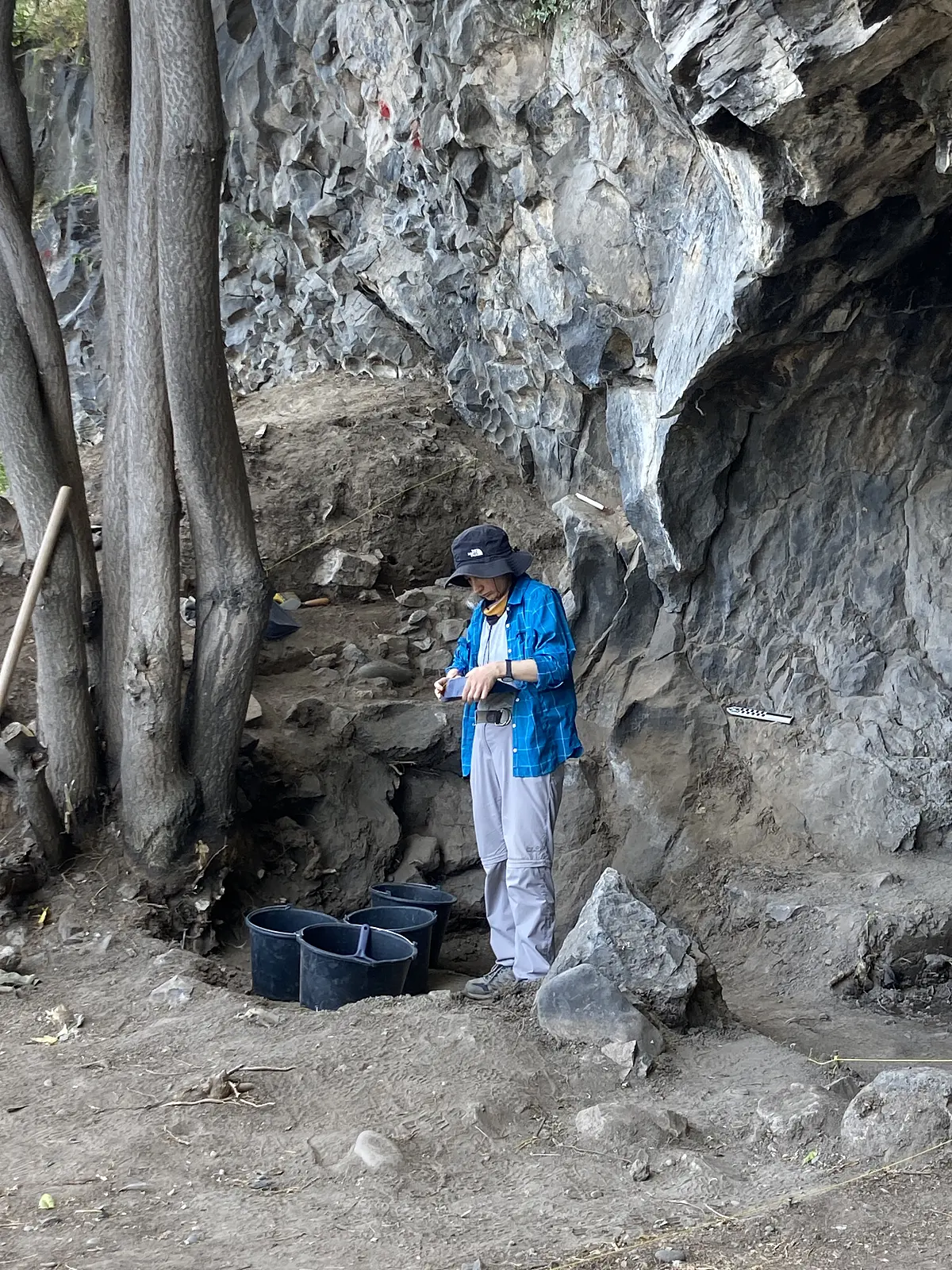 Forscherin in der Höhle neben Eimern