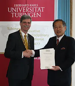 Rektor Prof. Dr. Bernd Engler (links) übergibt den Universitätspreis an Eiji Hatta, Ph. D., den Präsidenten der Dôshisha-Universität in Kyôto. Foto: Simona Steeger