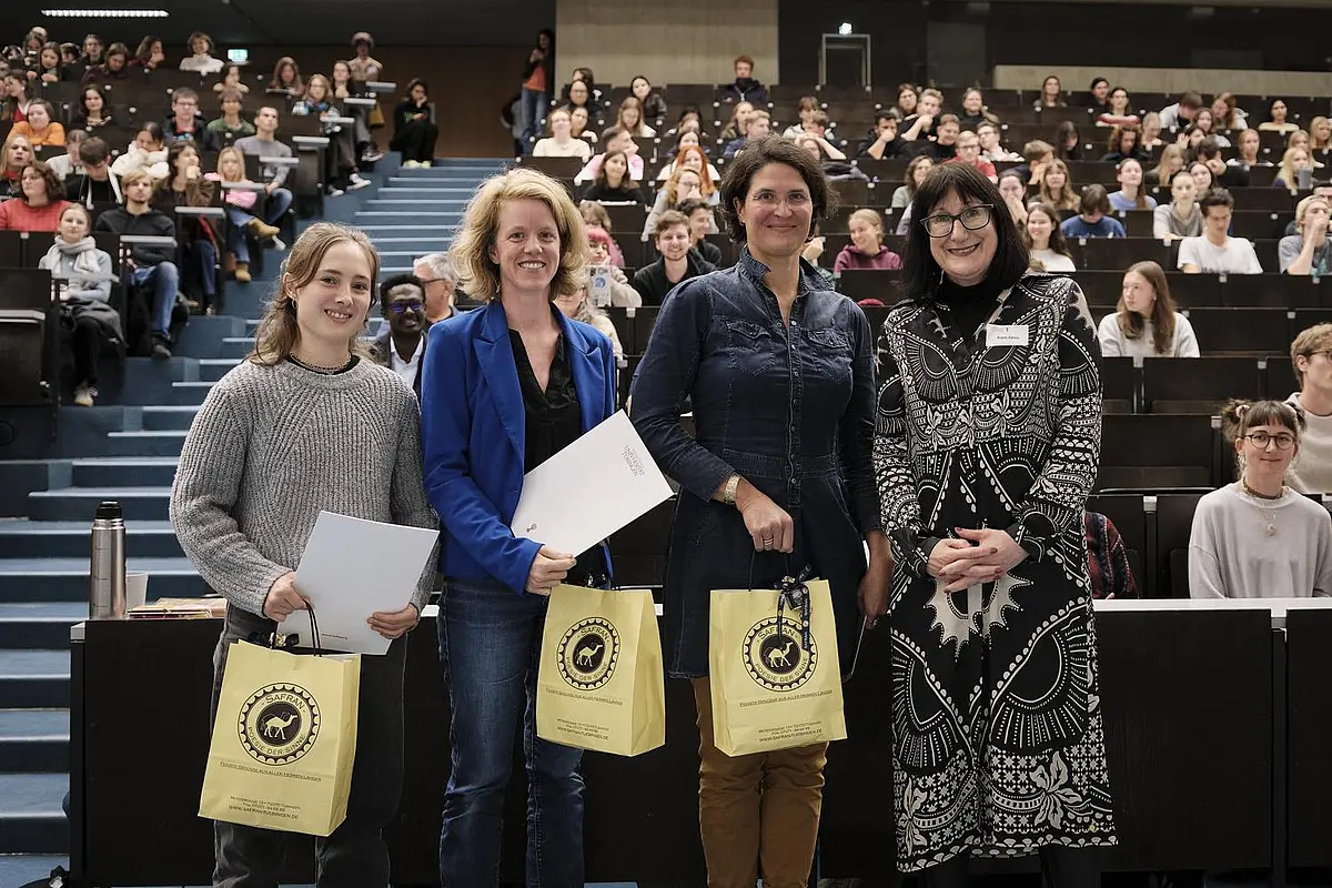 Foto der Preisträgerinnen mit Prorektorin vor vollbesetztem Hörsaal