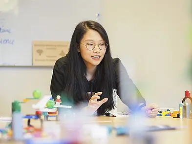Frau am Tisch mit Legosteinen