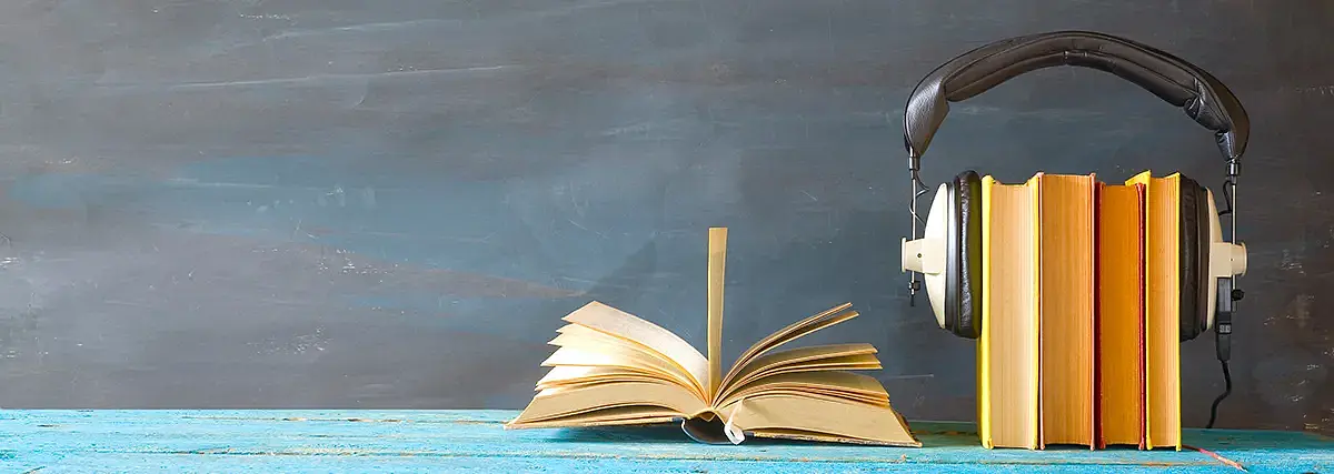 Bücher mit einem darauf platzierten Kopfhörer