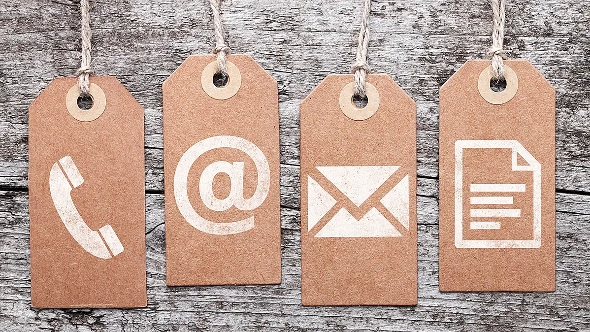 Vier Pappetiketten, die die Symbole für Telefon, Webseite, Emailadresse und Dokumente zeigen.