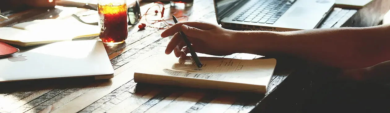 This is a symbolic Picture of a person writing an application in a café.