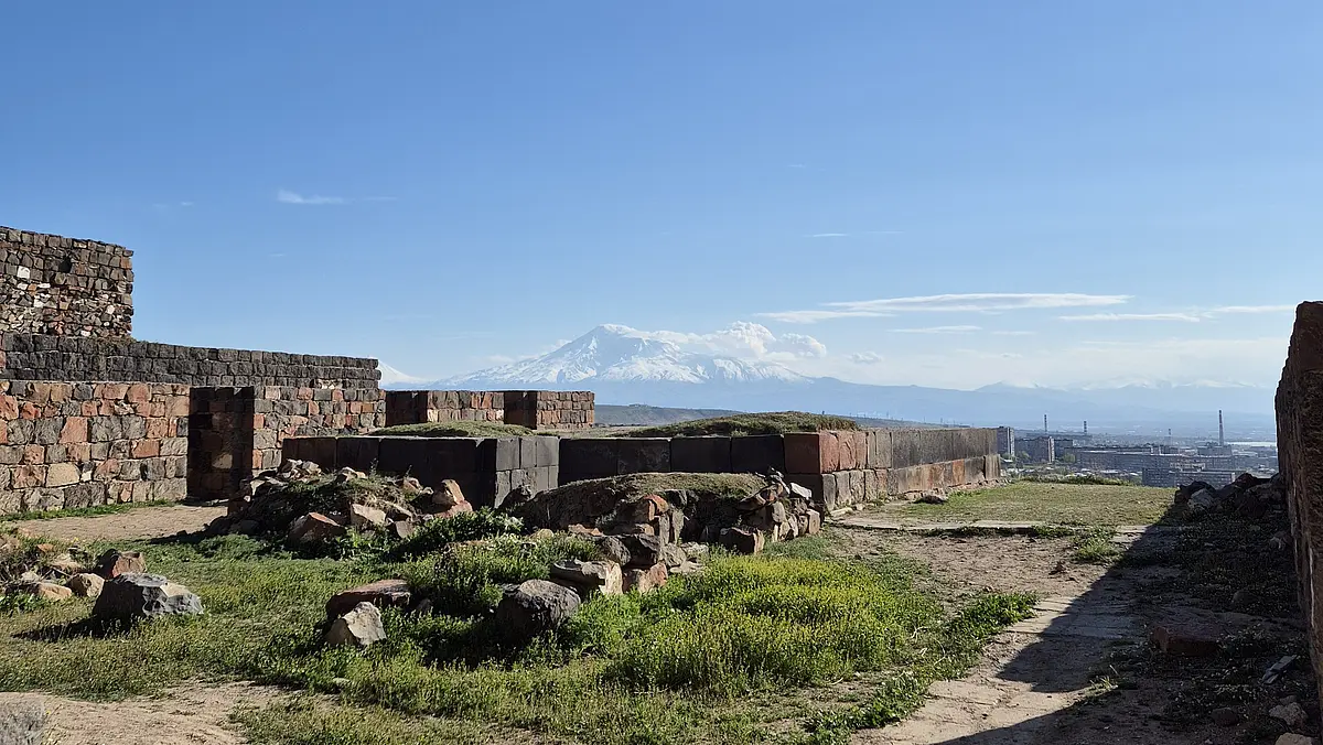 Die archäologischen Überreste von Erebuni mit der modernen Stadt Jerewan und dem Berg Ararat im Hintergrund 