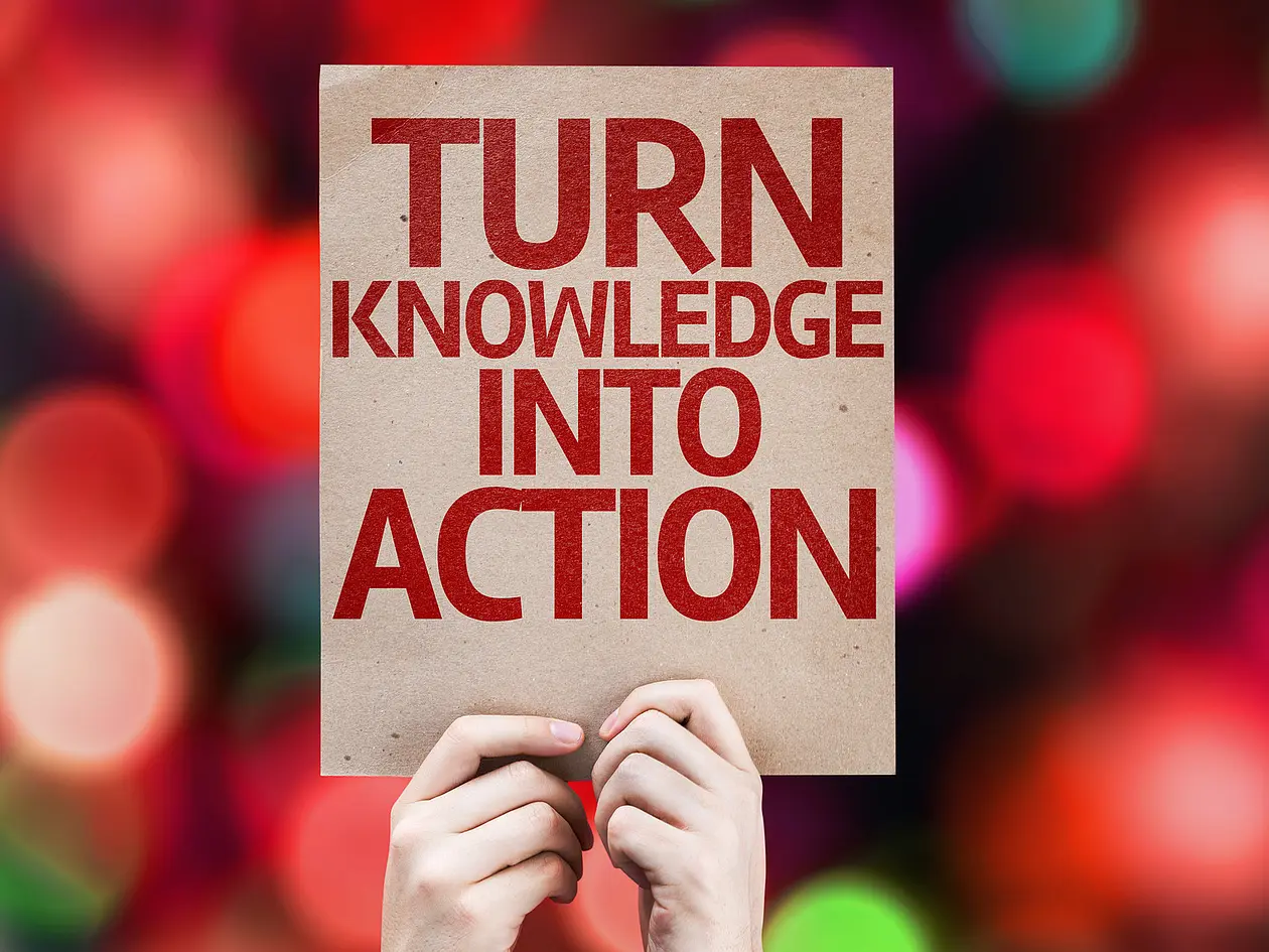 [Translate to Englisch:] Zwei Hände halten einen Karton mit der Aufschrift "Turn Knowledge into Action".