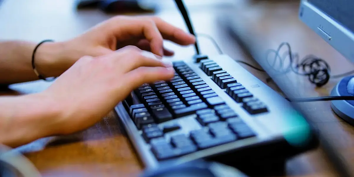 Person schreibt auf einer Computertastatur