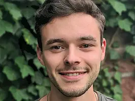 Die Fotographie zeigt Herrn Moritz Adam, der in die Kamera lächelt.