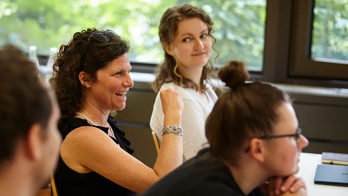 Vier gespannt und interessiert wirkende Forschende blicken zu einem Menschen, den man nicht sieht. Zertifikatsprogramm Wissenschaftskommunikation und mediale Kompetenz