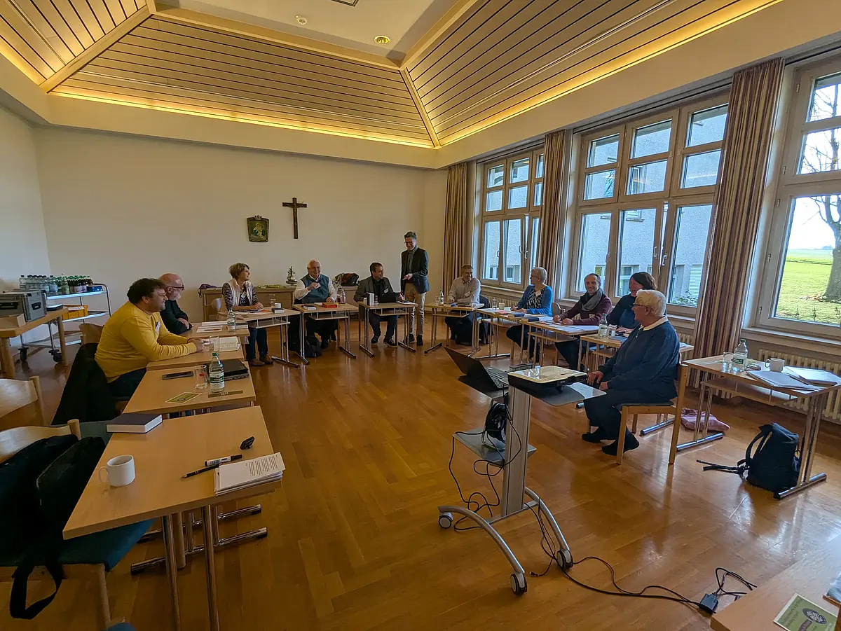 Auf dem Bild sind elf Menschen zu sehen, darunter auch Prof. Winter. Die Menschen sitzen an Tischen, die zu einem U gestellt worden sind.