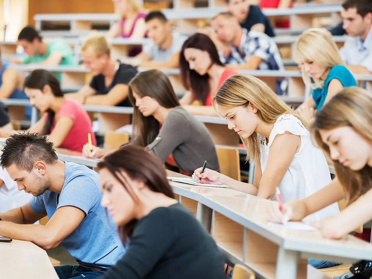 Studentinnen und Studentent im Hörsaal während einer Prüfung.