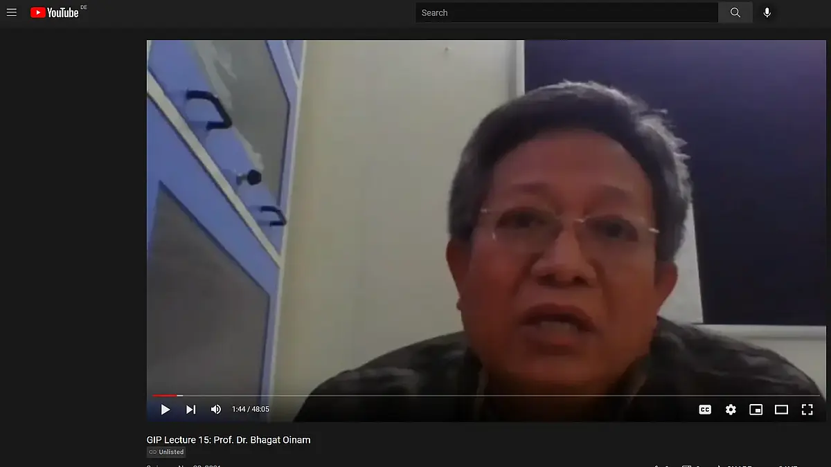 A middle-aged man speaks into a webcam