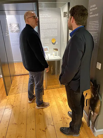 Dieter Gruppe, Vorsitzender des Vereins KZ Gedenkstätte Bisingen, und Ausstellungskurator PD Dr. Lukas Werther im Dialog vor einer der neuen Vitrinen.
