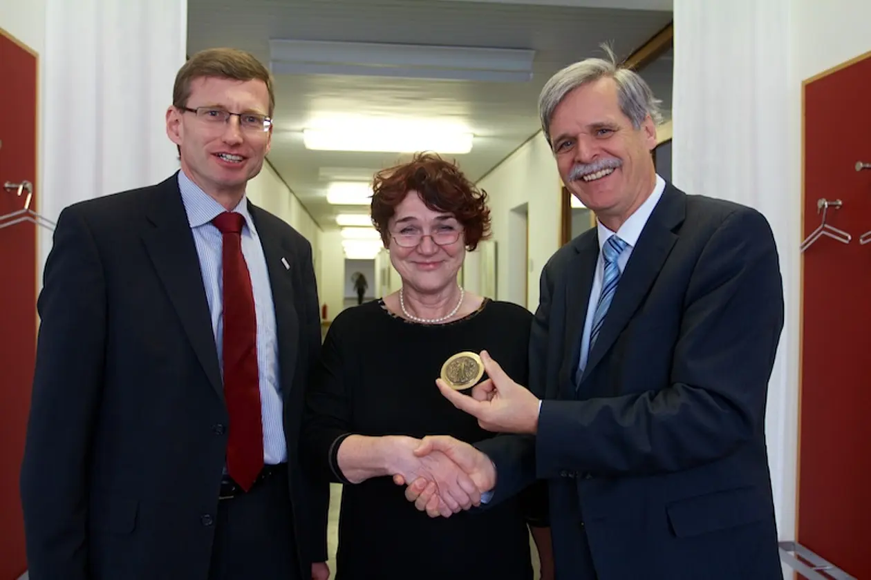 Rektor Professor Dr. Bernd Engler überreicht Jutta Pickel die Universitätsmedaille in Bronze, links: Kanzler Dr. Andreas Rothfuß. Foto: Friedhelm Albrecht