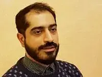 A man in his late 30s with dark hair and beard