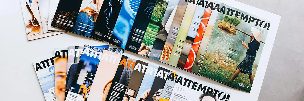 Mehrere Printausgaben des Forschungsmagazins attempto liegen auf einem Tisch